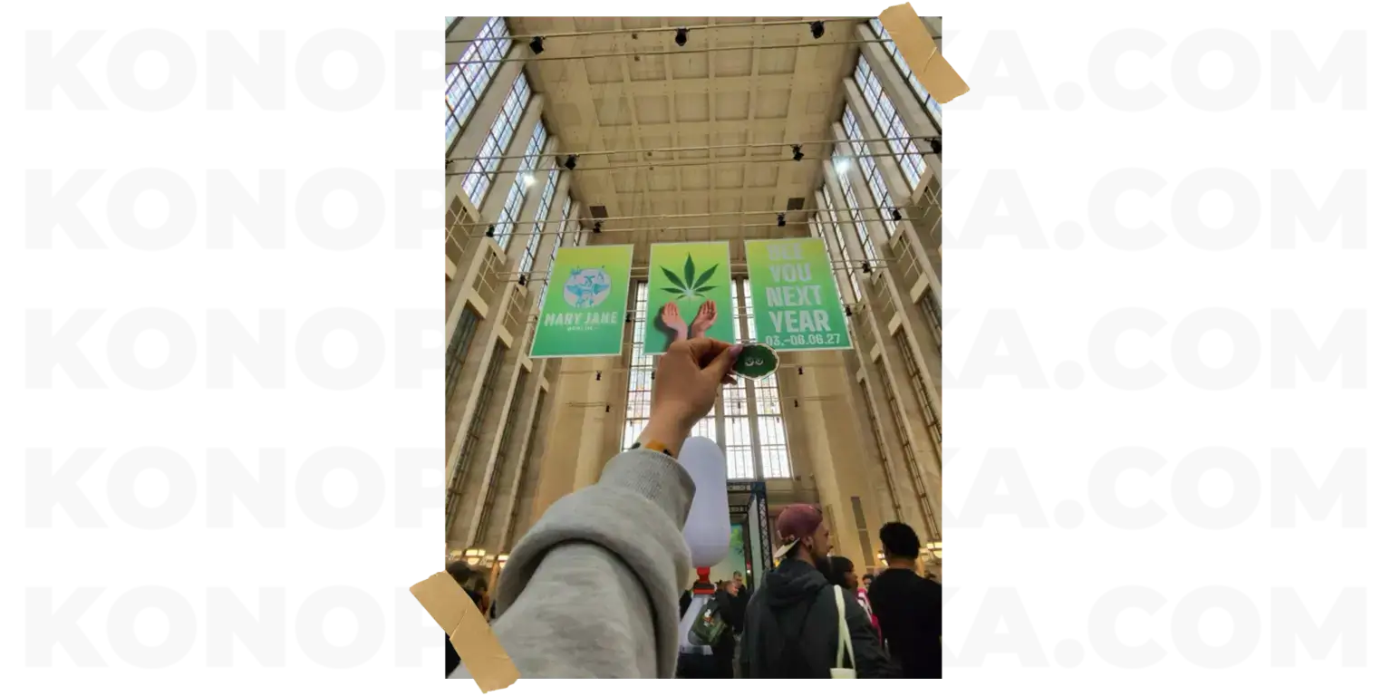 Інтер'єр павільйону Messe Berlin з підвішеними плакатами Mary Jane Berlin та зображенням листя марихуани.